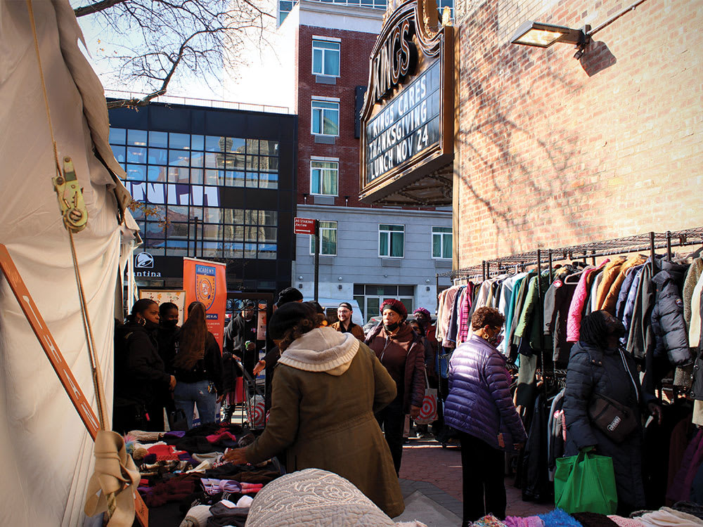 A shot of patrons participating at the annual winter coat drive in the Kings Theatre courtyard next to the theatre.