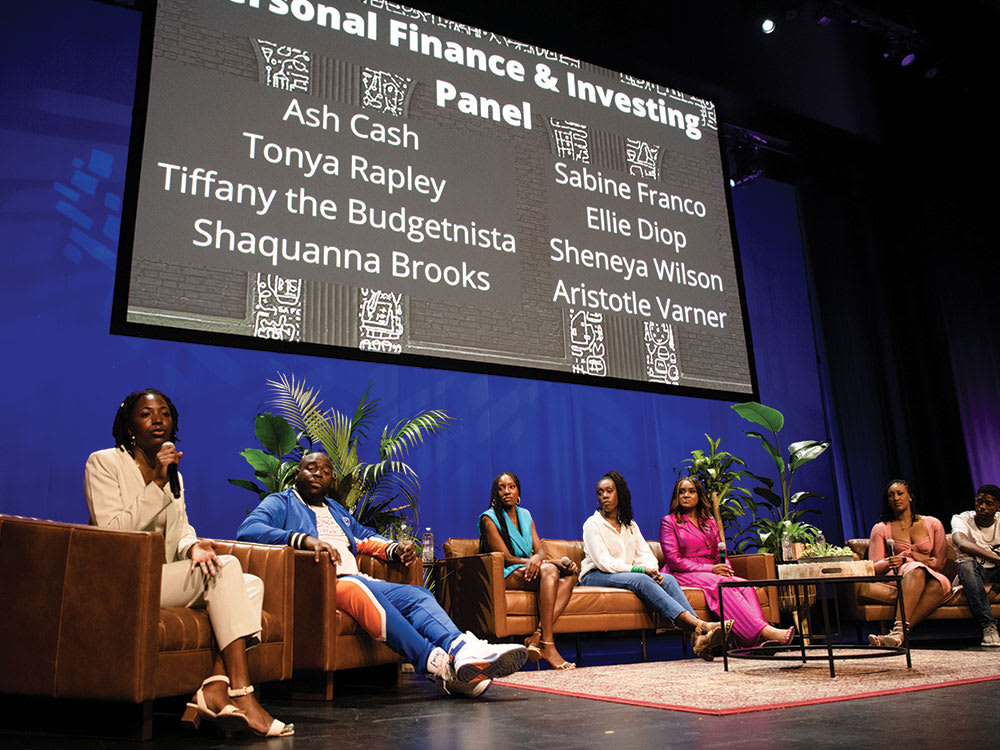 A stage shot of panelists sitting together for a personal finance discussion at the Black Money Forum at Kings Theatre.